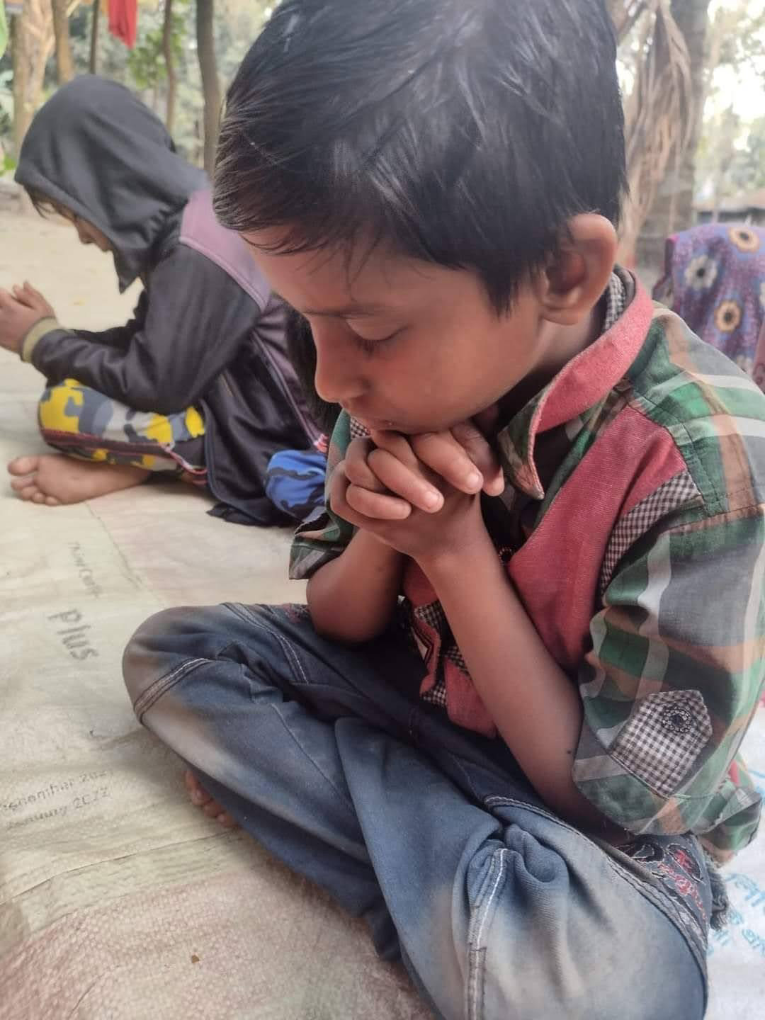 A child in Gonali praying with clasped hands