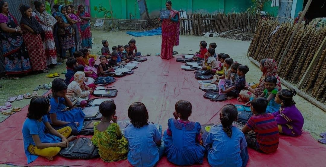 Children sitting in a circle for class at the school in Gonali
