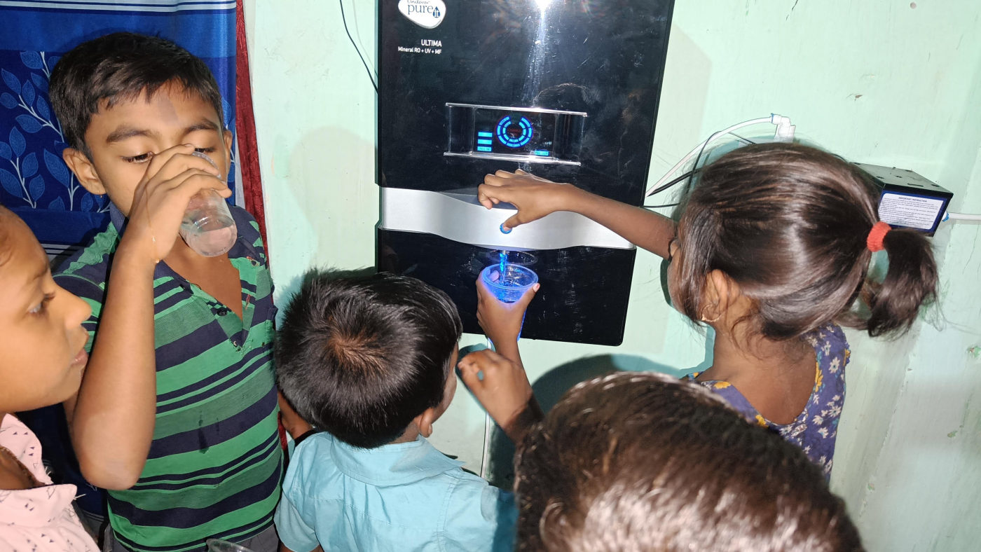 Children drinking clean water at a filter in Gonali