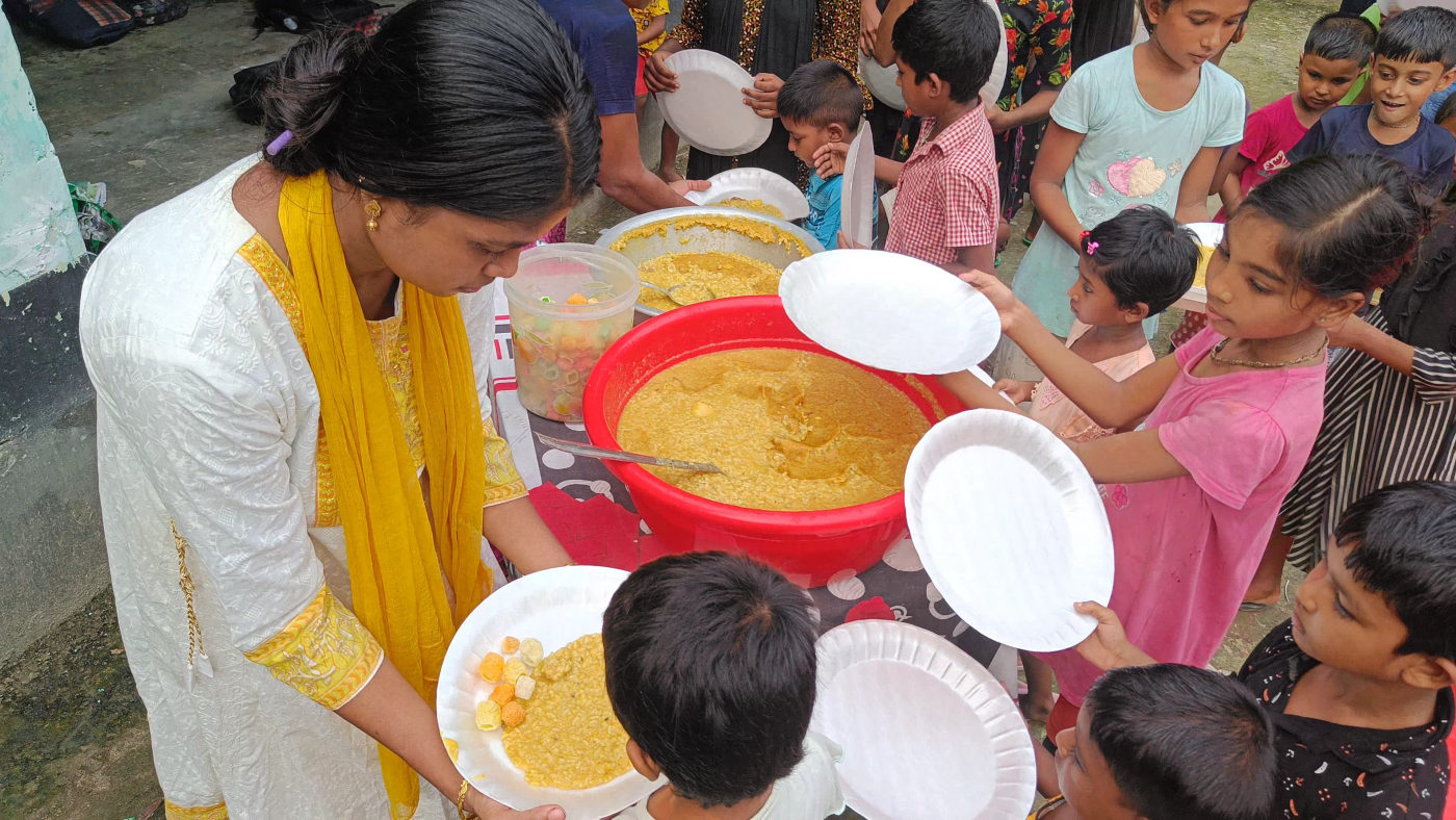 A volunteer serving a hot meal to children in Gonali